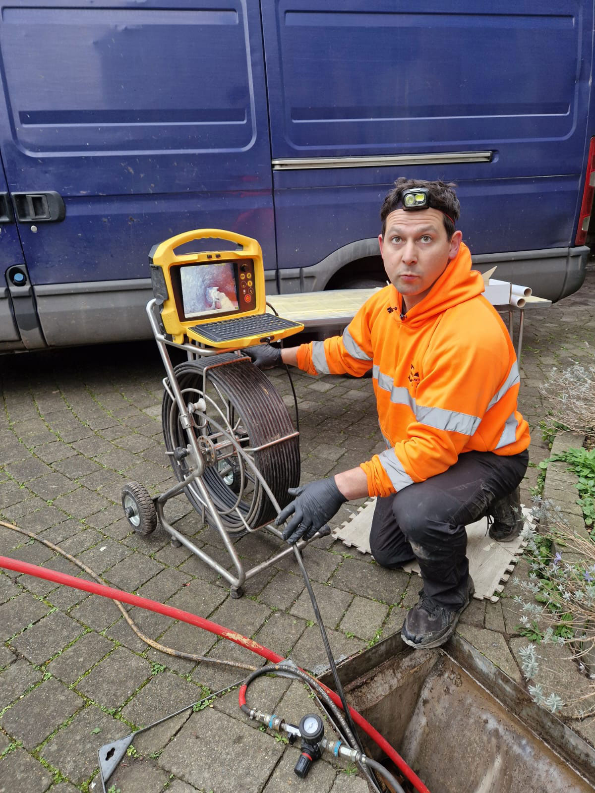 Declan from Drain Ace unblocking a drain in Weybridge using high pressure jetting and a Vivax V-Cam 6 CCTV drain inspection system