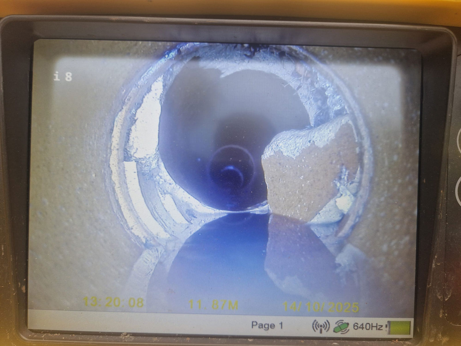 CCTV drain survey image showing broken section of drain pipe causing blockage in Cobham